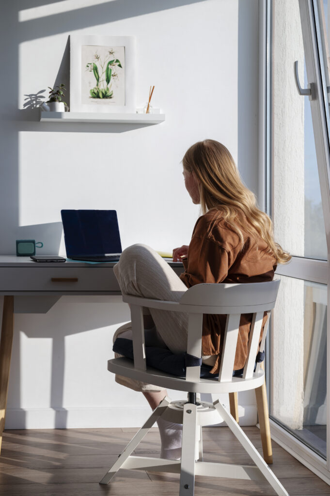 A focused business professional working on a laptop at home, symbolizing how outsourcing cleaning allows more time for productivity and work-life balance.